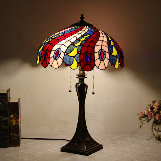 Veltora Tiffany style table lamp with a colorful stained glass peacock feather shade and a dark resin base.
